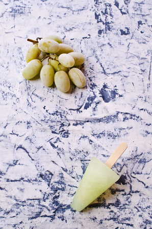 Ice lolly of green grapes on concrete background. Selective focus.の写真素材