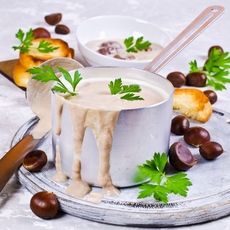 Cream soup of pureed chestnuts on a concrete background. Selective focus.の写真素材