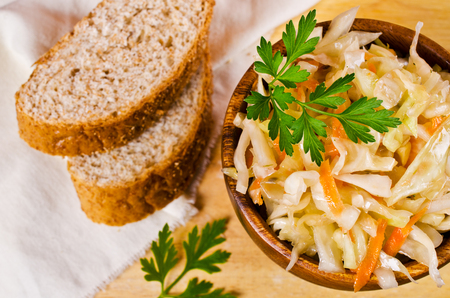 Traditional homemade sauerkraut with carrots, fennel seeds and fresh parsley. Selective focus.の写真素材