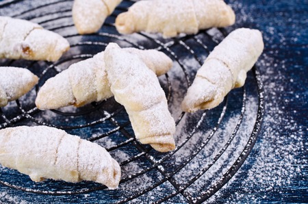Homemade cookies twisted, sprinkled with powdered sugar,  on a dark background. Selective focus.の写真素材