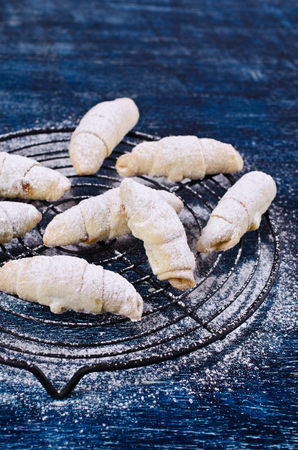 Homemade cookies twisted, sprinkled with powdered sugar,  on a dark background. Selective focus.の写真素材