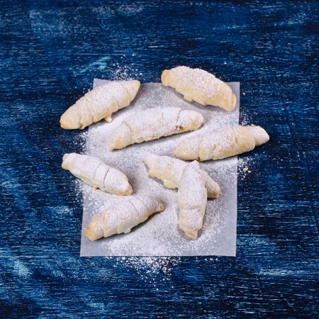 Homemade cookies twisted, sprinkled with powdered sugar,  on a dark background. Selective focus.の写真素材