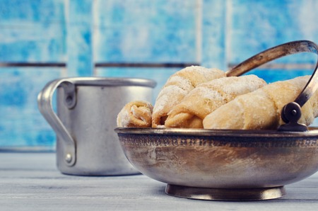 Homemade cookies twisted, sprinkled with powdered sugar,  on wooden background. Selective focus.の写真素材