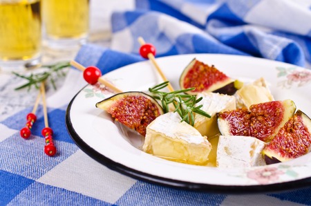 Pieces of Camembert and figs with honey on the plate. Selective focus.の写真素材