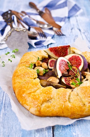 Homemade open pie with figs and cashew nuts on a wooden background. Selective focus.の写真素材