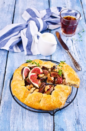 Homemade open pie with figs and cashew nuts on a wooden background. Selective focus.の写真素材