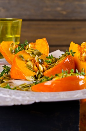 Baked pumpkin slices with seeds and thyme. Selective focus.の写真素材
