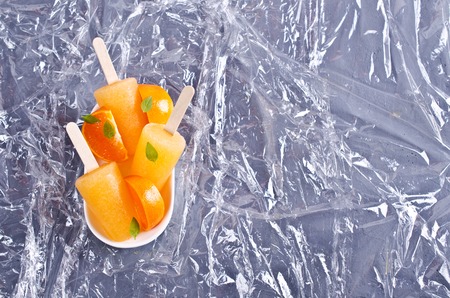 Homemade ice cream on a stick from an orange. Selective focus.の写真素材