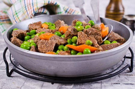 Meat stew with peas and carrots in a rustic style. Selective focus.の写真素材