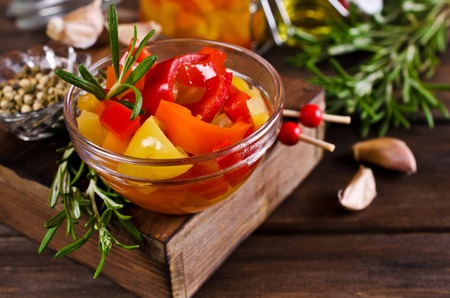 Homemade canned peppers with spices on a wooden background. Selective focus.の写真素材