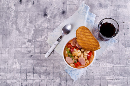 Thick vegetable soup with beans and sausages. Selective focus.