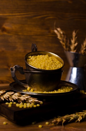 Dry round pasta on the wooden background. Selective focus.の写真素材