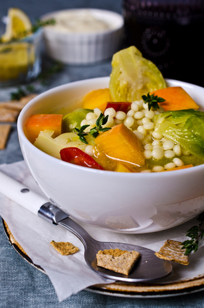 Soup with vegetables and pasta on textile background. Selective focus.の写真素材