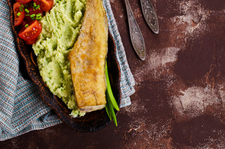 Fried  pollock with vegetables on a plate. Selective focus.の写真素材