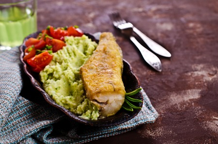 Fried  pollock with vegetables on a plate. Selective focus.の写真素材
