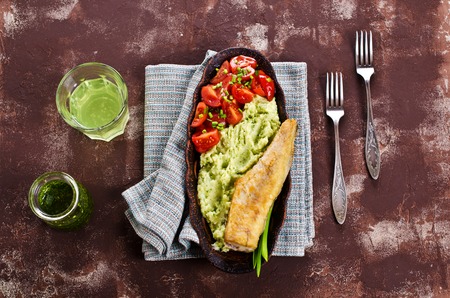Fried  pollock with vegetables on a plate. Selective focus.の写真素材