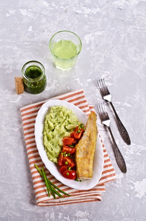 Fried  pollock with vegetables on a plate. Selective focus.の写真素材