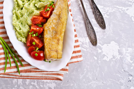 Fried  pollock with vegetables on a plate. Selective focus.の写真素材