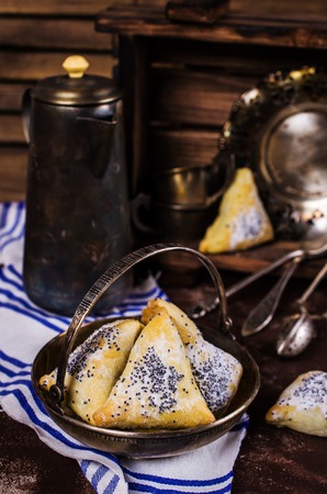 Triangular cookies with poppy seeds and powdered sugar. Selective focus.の写真素材