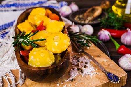 Marinated yellow pattypan and paprika on a wooden background. Selective focus.の写真素材