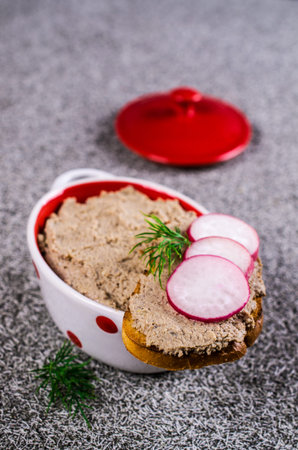 Toast with liver pate and radish on a dark background. Selective focus.