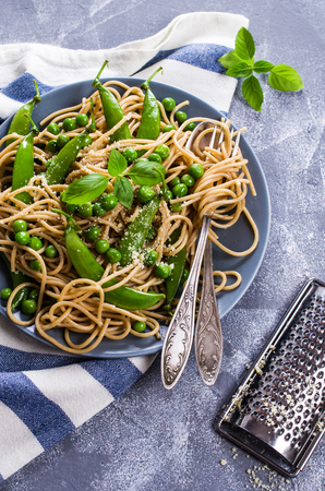 Dark spaghetti with green peas and parmesan. Selective focus.の写真素材