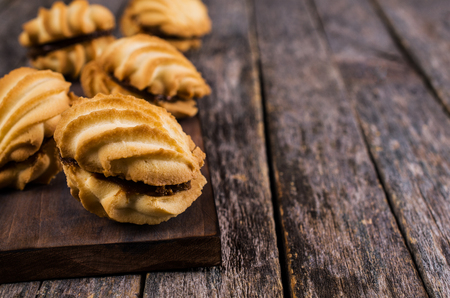 Traditional shortbread cookies with caramel filling on a wooden background. Selective focus.の写真素材
