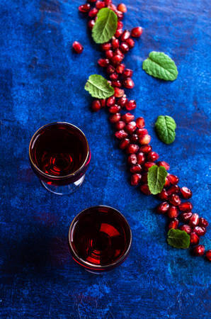 Transparent burgundy drink with pomegranate seeds and mint. Selective focus.の写真素材