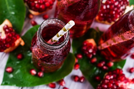 Cold transparent pomegranate drink on a wooden background. Selective focus.の写真素材