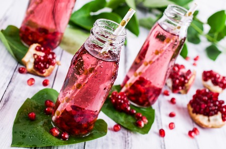 Cold transparent pomegranate drink on a wooden background. Selective focus.の写真素材