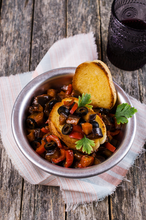 Stewed vegetables in sauce with parsley leaves and toast. Selective focus.の写真素材