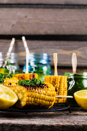 Grilled corn on sticks with green sauce. Selective focus.の写真素材