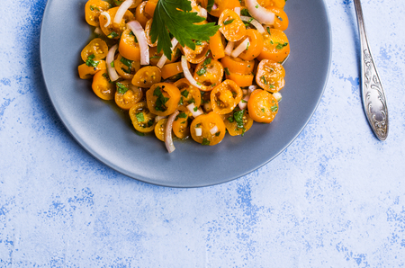 Salad of yellow tomato with onion and parsley. Selective focus.の写真素材