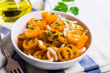 Salad of yellow tomato with onion and parsley. Selective focus.の写真素材