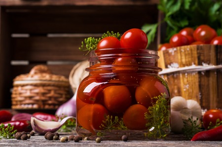 Marinated cherry tomatoes with spices on a wooden background. Selective focus.の写真素材