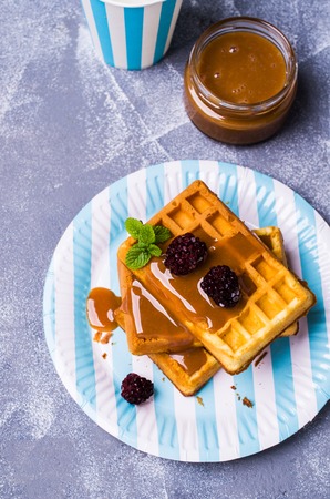 Traditional Belgian waffles with caramel topping and blackberries. Selective focus.の写真素材