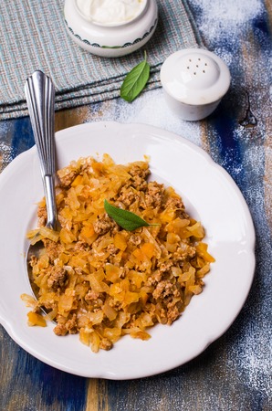 Stewed vegetables with sauce and minced meat on a wooden background. Selective focus.の写真素材