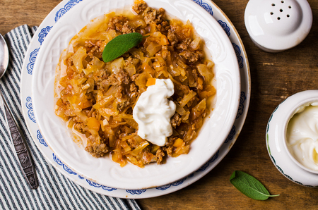 Stewed vegetables with sauce and minced meat on a wooden background. Selective focus.の写真素材