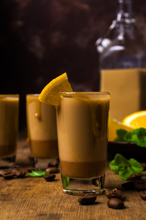 Creamy coffee liqueur with caramel on a wooden background. Selective focus.