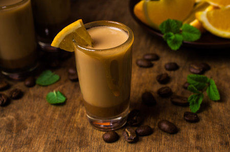 Creamy coffee liqueur with caramel on a wooden background. Selective focus.