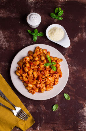 Pasta with vegetables and tomato sauce on a concrete background. Selective focus.の写真素材