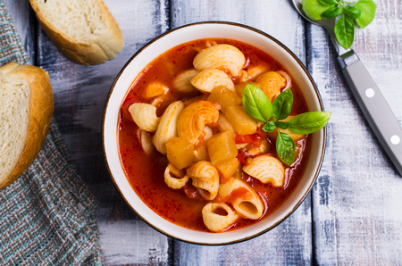 Tomato soup with pasta and vegetables on a wooden background. Selective focus.の写真素材