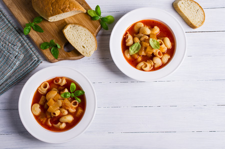 Tomato soup with pasta and vegetables on a wooden background. Selective focus.の写真素材
