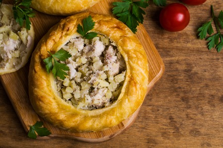 Round meat pie with vegetables and spices on a wooden background. Selective focus.の写真素材