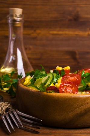 Salad with raw vegetables and parsley on a wooden background. Selective focus.の写真素材