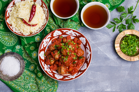 Traditional spicy meatballs in tomato sauce with garnish on a concrete background. Selective focus.の写真素材