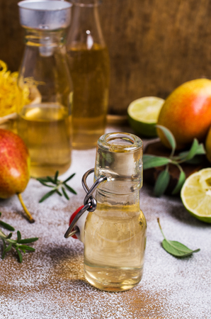 Homemade fruit vinegar on rustic wooden background. Selective focus.の写真素材