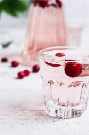 Transparent pink drink with cranberry in the glass on a light background. Selective focus.の写真素材