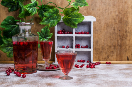 Transparent red drink with cranberries on a wooden background. Selective focus.の写真素材