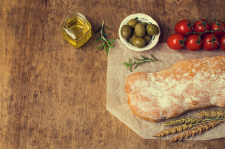 Traditional ciabatta bread on a wooden background with spices and vegetables. Selective focus.の写真素材
